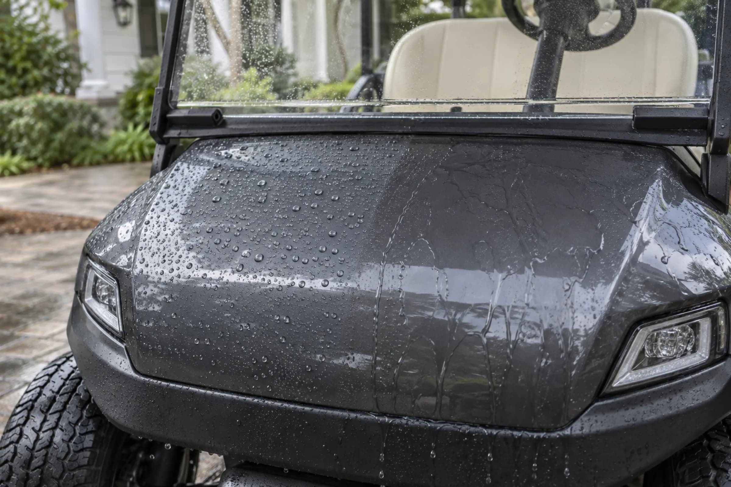 Water beading on the ceramic-coated front cowl of a golf cart