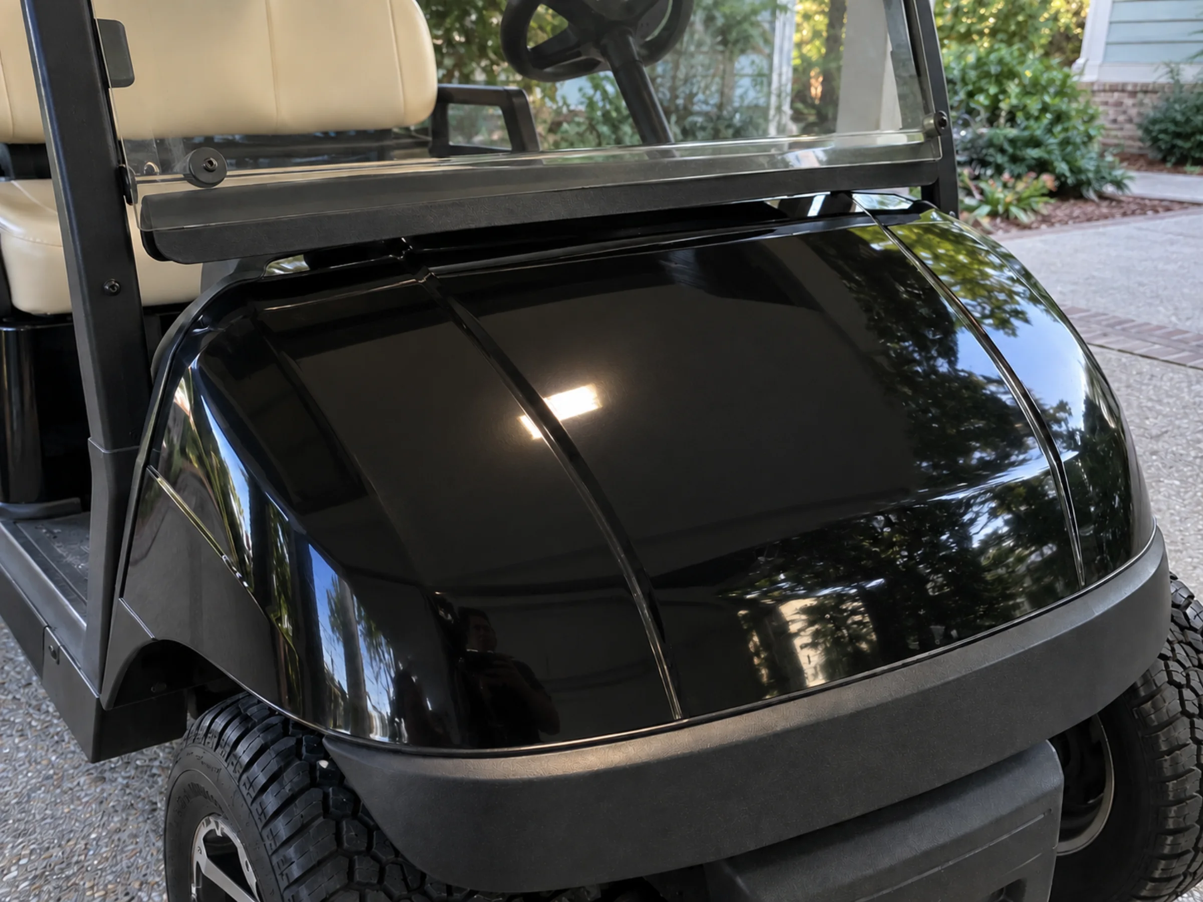 Same black golf cart cowl with deep clear reflections after correction and coating