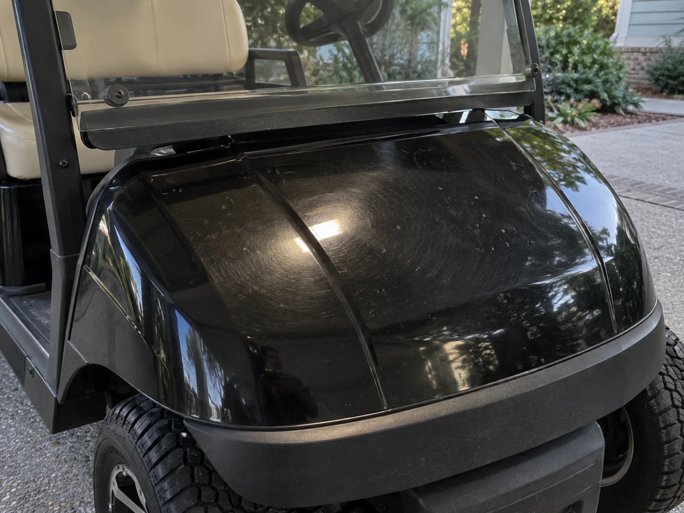 Black golf cart cowl showing wash swirls and light oxidation haze
