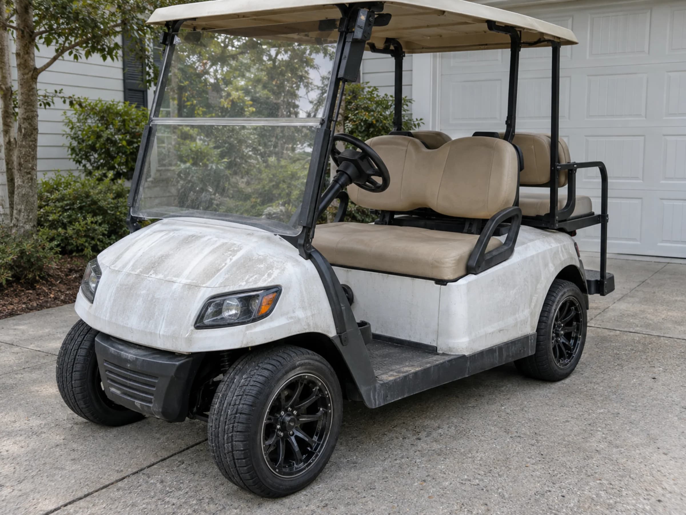 White golf cart with chalky oxidation and salt streaks across the front cowl