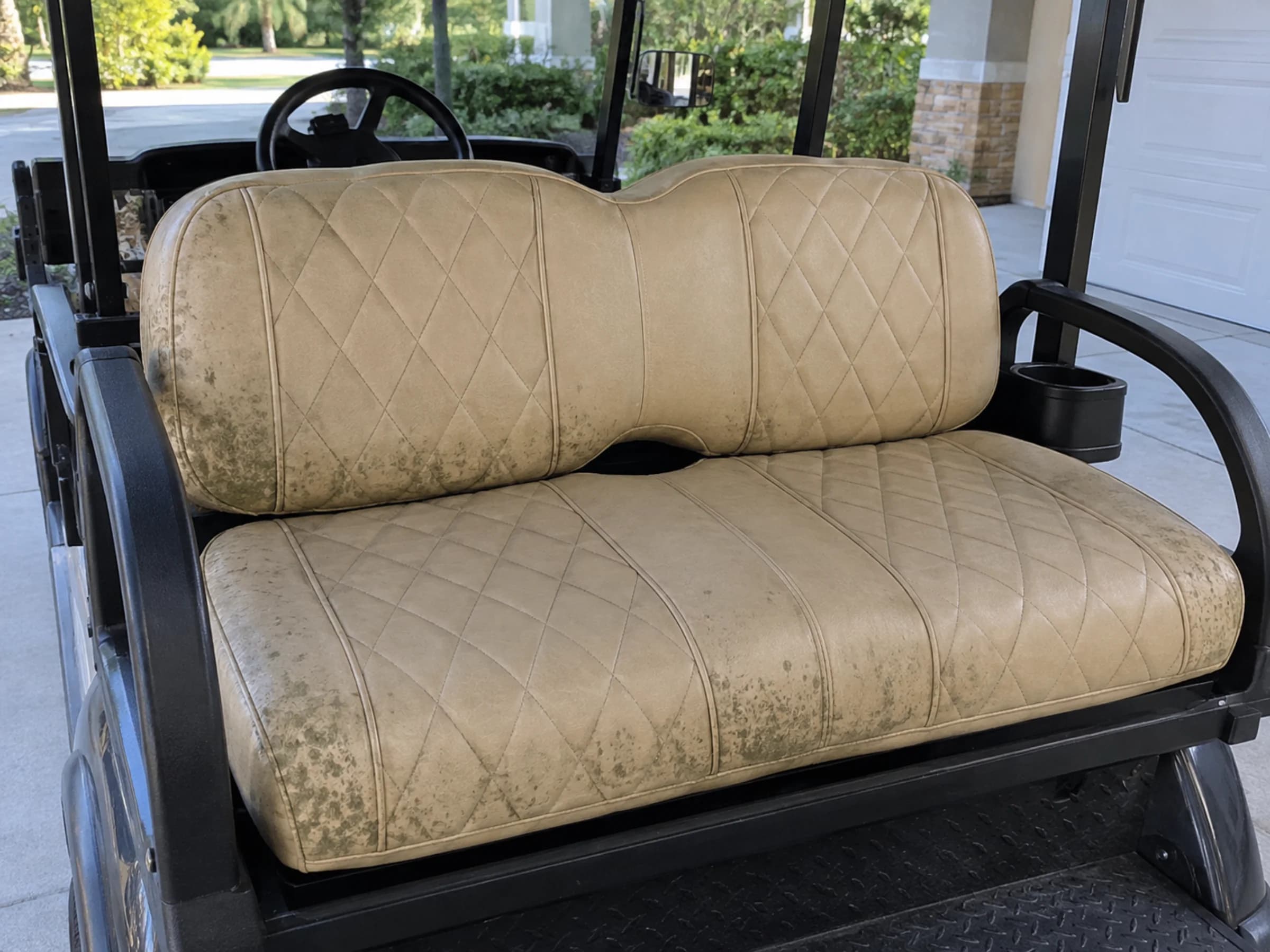 Tan golf cart bench seat with mildew spotting concentrated along its seams